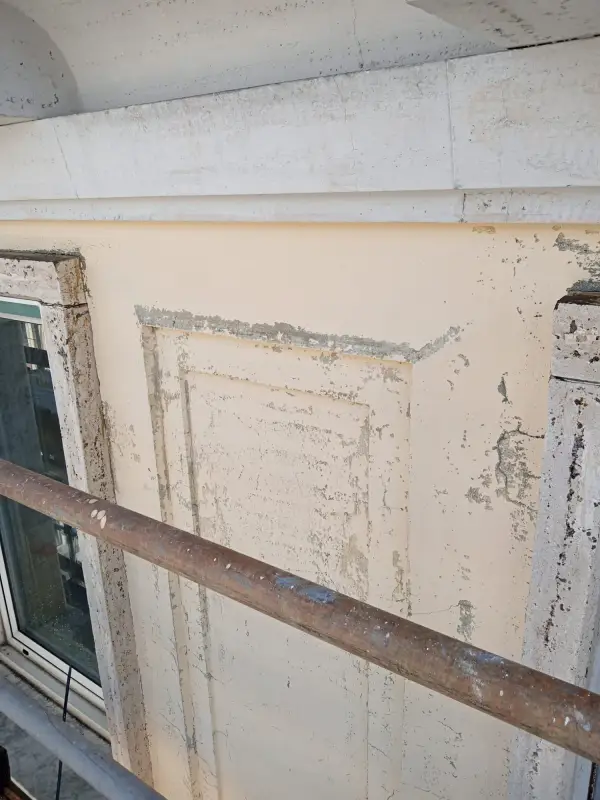 Cornice della finestra con l'intonaco scrostato, vista dal ponteggio