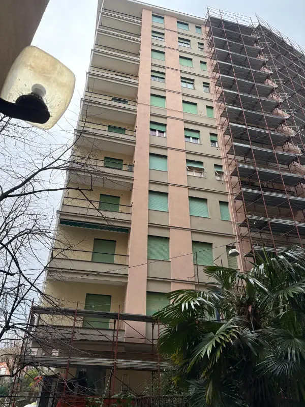 Palazzo con il ponteggio montato su un lato, tra le palme